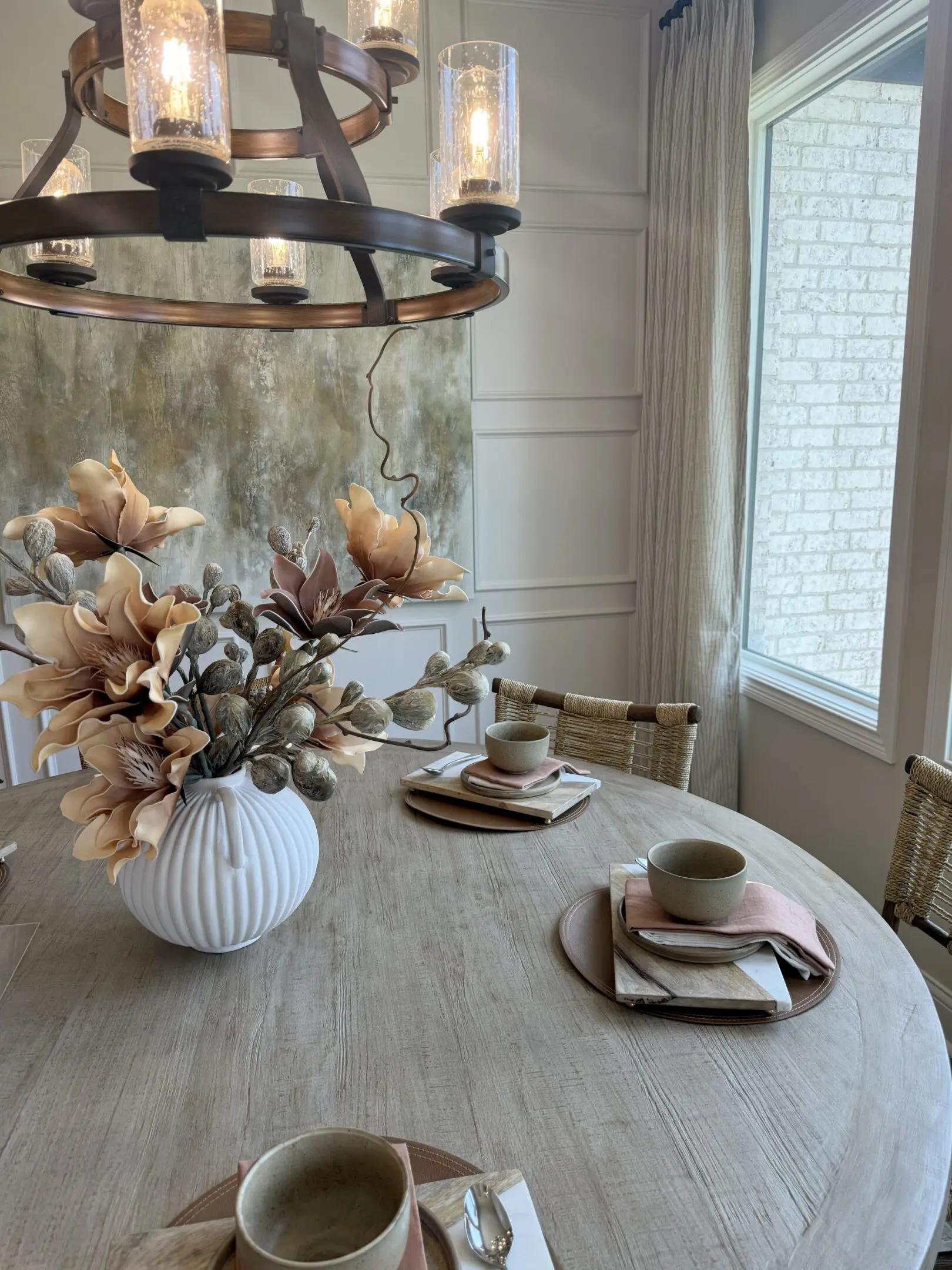Round dining table with floral centerpiece and chandelier