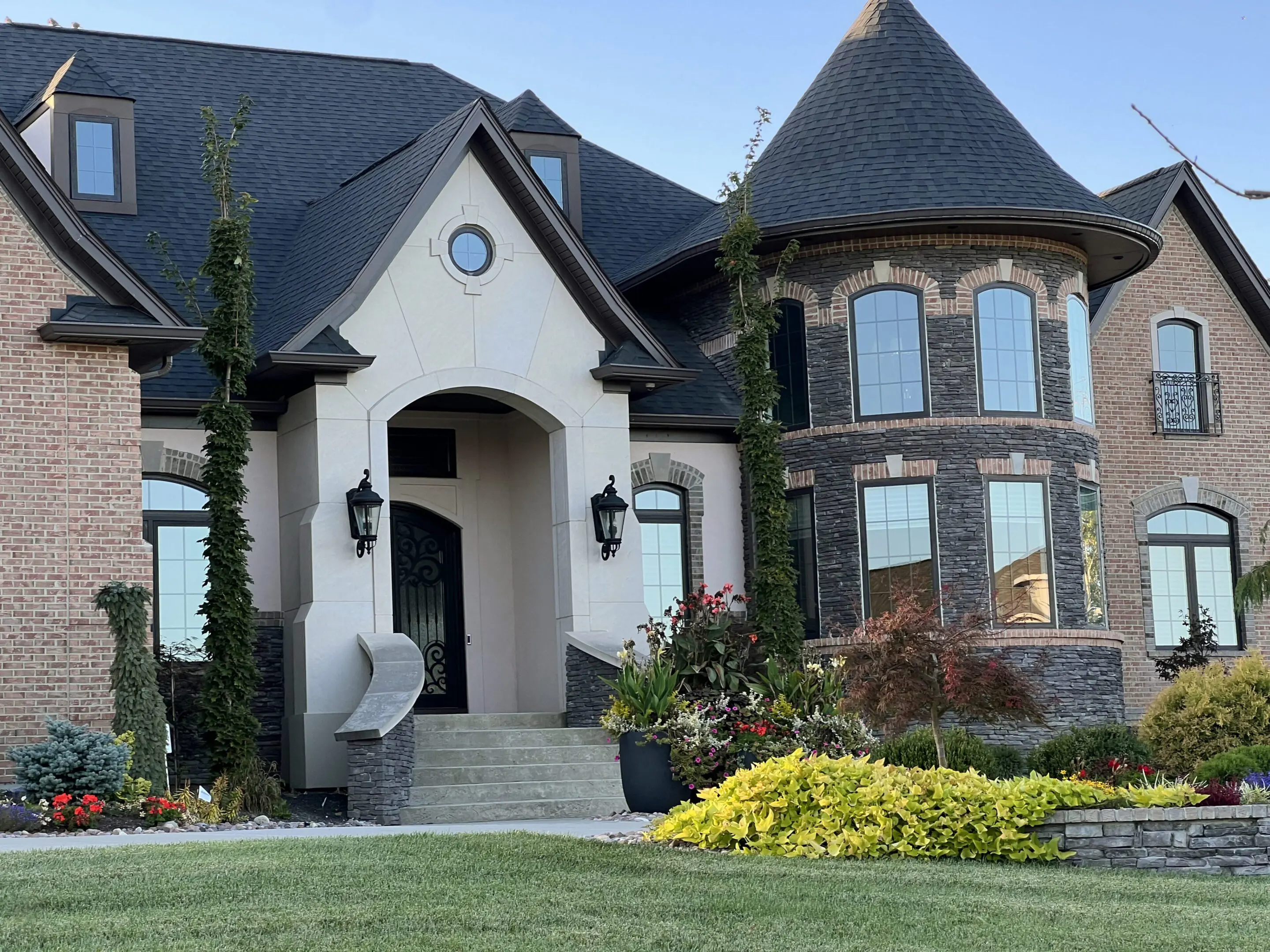 Luxury brick mansion with turret and landscaping