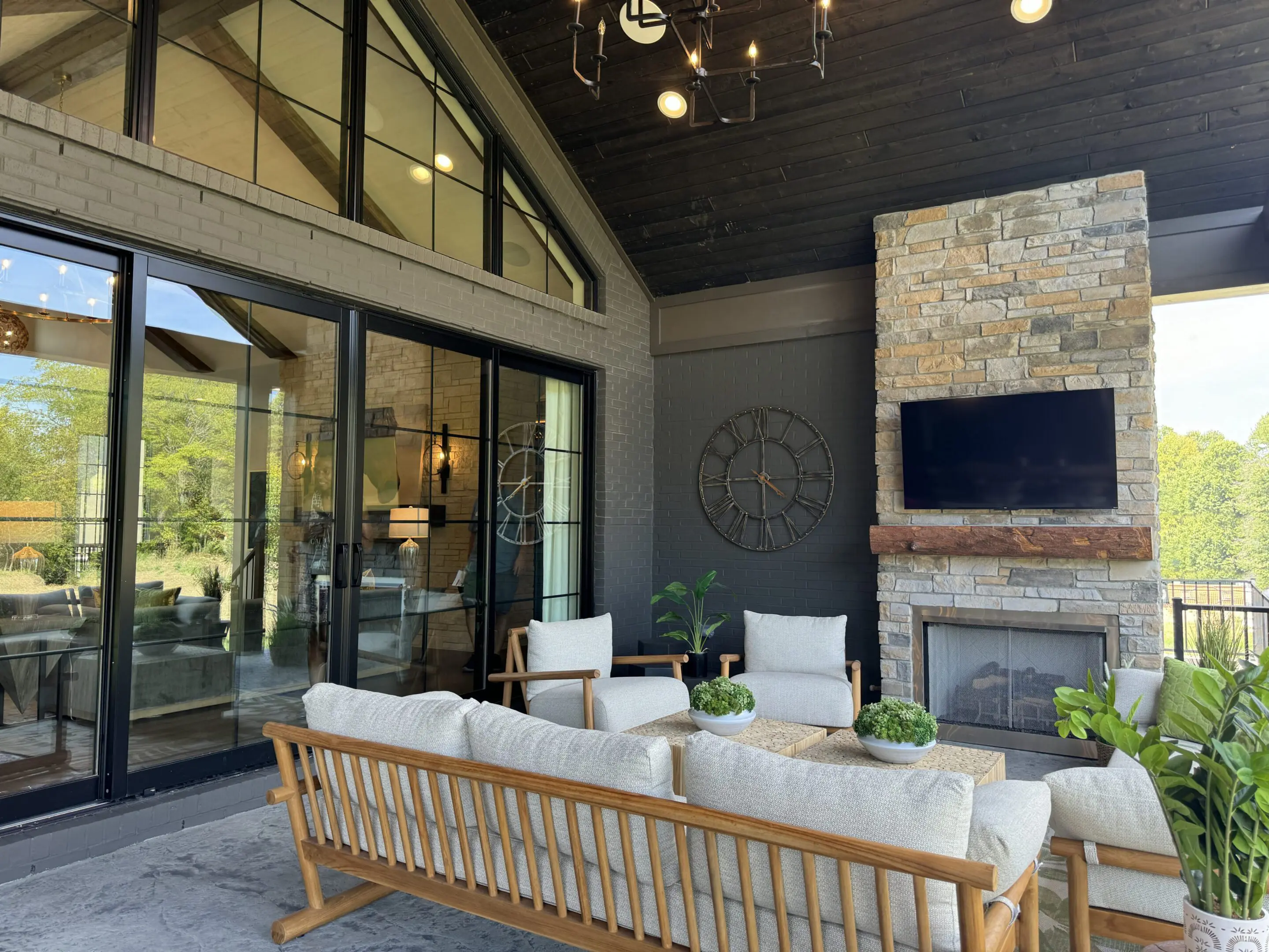 Cozy covered patio with stone fireplace and seating