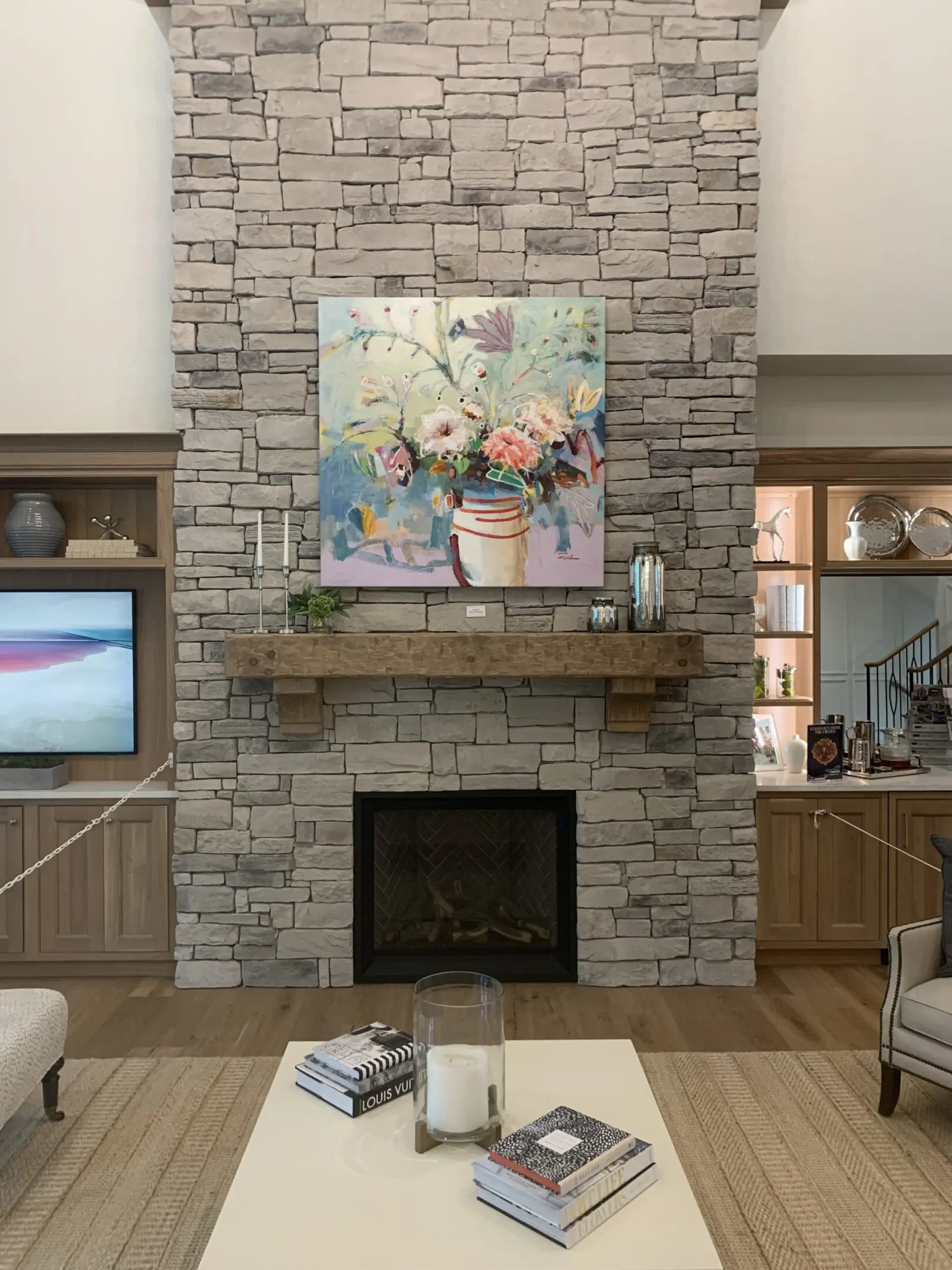 Living room with stone fireplace and floral painting