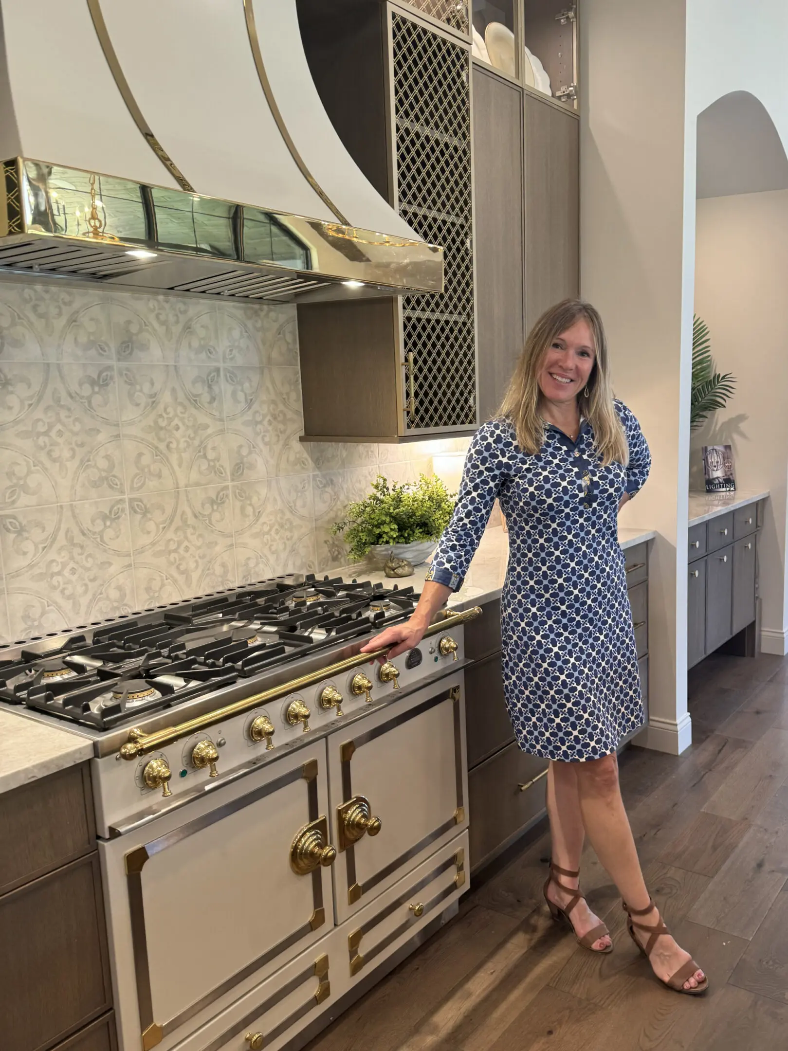 Smiling woman beside ornate kitchen range
