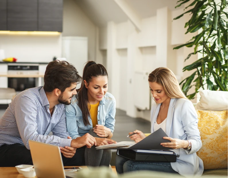 Group reviewing paperwork in cozy home setting.