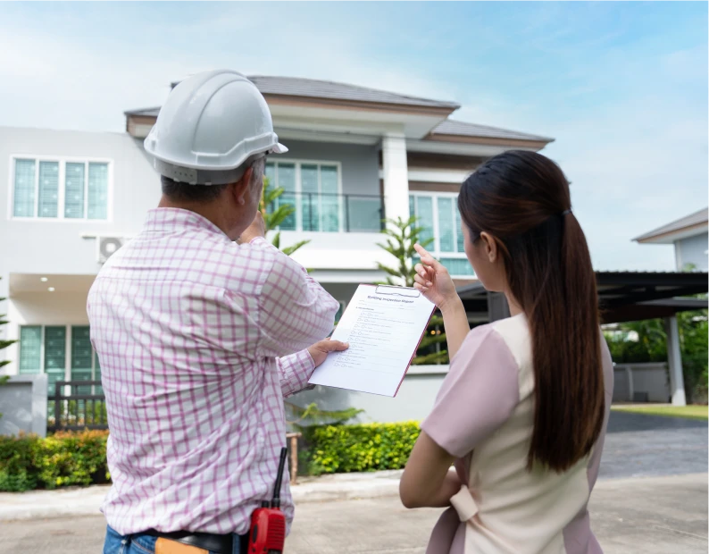 Construction worker and client reviewing blueprint